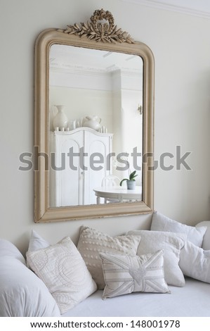 stock-photo-framed-mirror-above-daybed-with-cushions-148001978.jpg